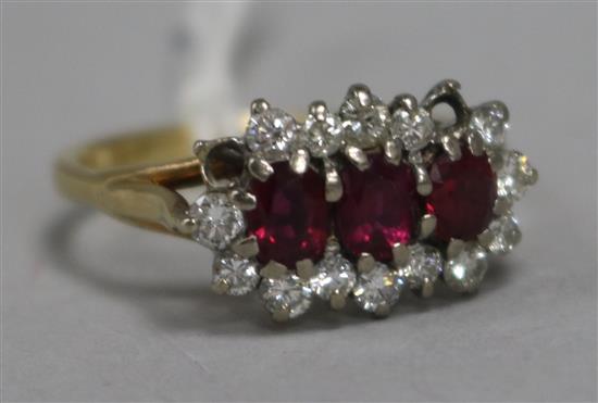 An 18ct gold, ruby and diamond triple cluster ring, (two diamonds missing), size U.